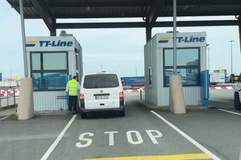 Fährhafen Checkin vor uns steht ein weißer VW Bus und checkt ein.