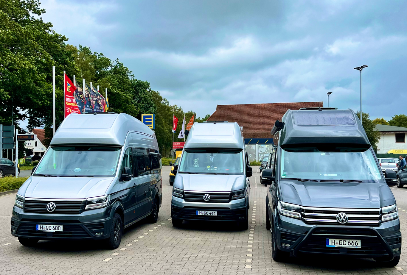 Drei Grand California 600 nebeneinander auf einem Supermarktparkplatz